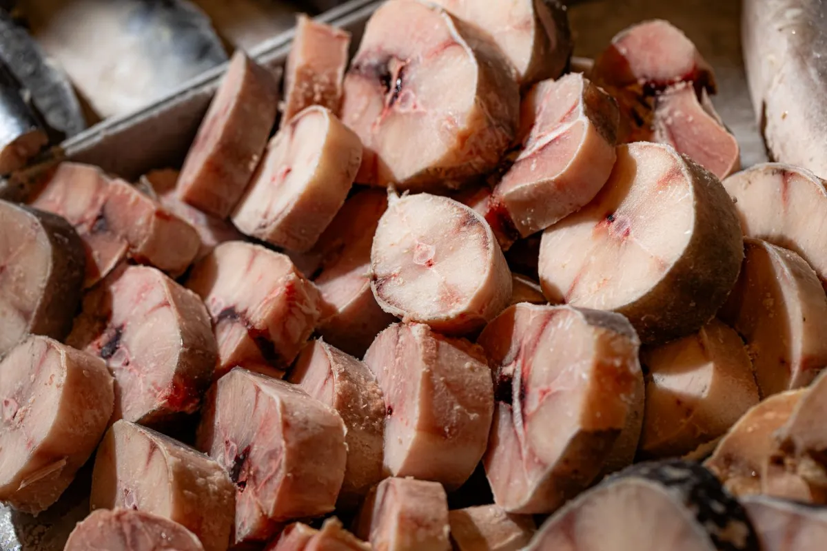 Postas de peixe empilhadas no balcão, frias e cortadas na hora